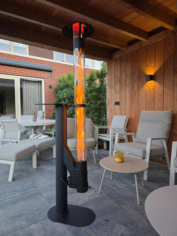 Pelletofen auf einer überdachten Terrasse mit hellgrauen Loungesesseln und Beistelltisch